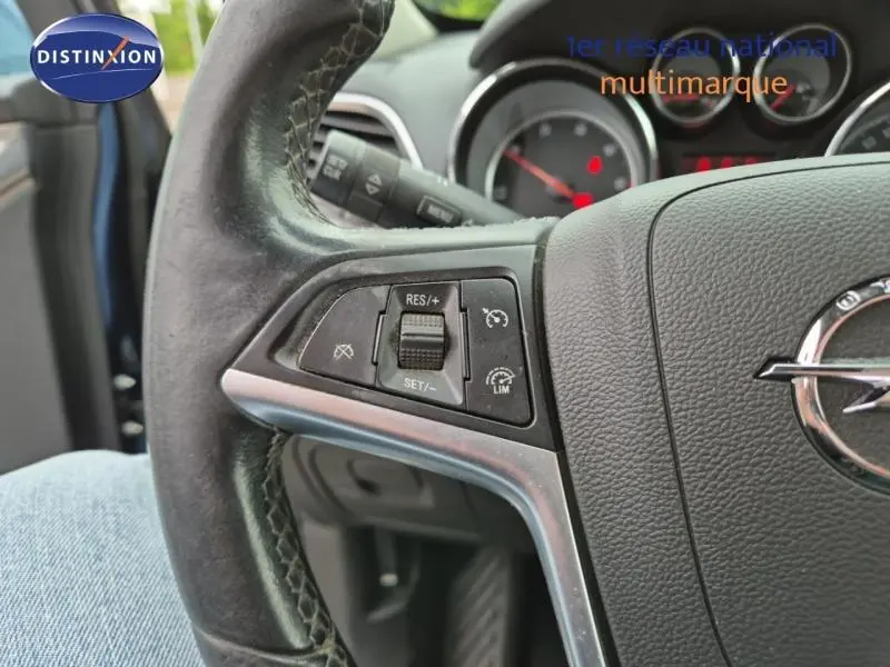Gros plan sur le volant cuir de l’Opel Mokka bleu outremer, avec commandes de régulateur de vitesse visibles.