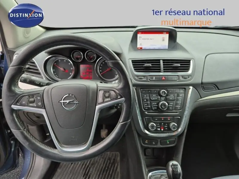 Vue intérieure frontale du tableau de bord et volant cuir de l'Opel Mokka 2015 avec écran central et commandes intégrées.