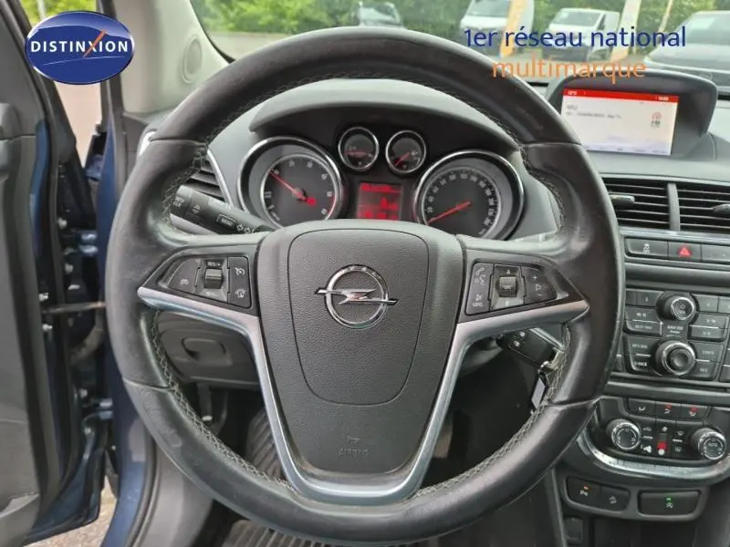 Vue centrée sur le volant cuir de l’Opel Mokka bleu outremer, avec tableau de bord et écran multimédia visibles.