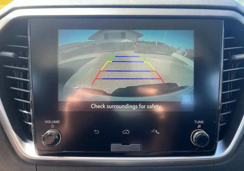 Écran tactile intérieur affichant la caméra de recul du pick-up Isuzu D-MAX blanc, vue arrière avec repères colorés.