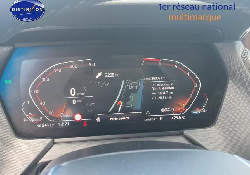 Tableau de bord numérique de BMW Série 1 gris foncé, affichant la vitesse et la navigation en plein jour