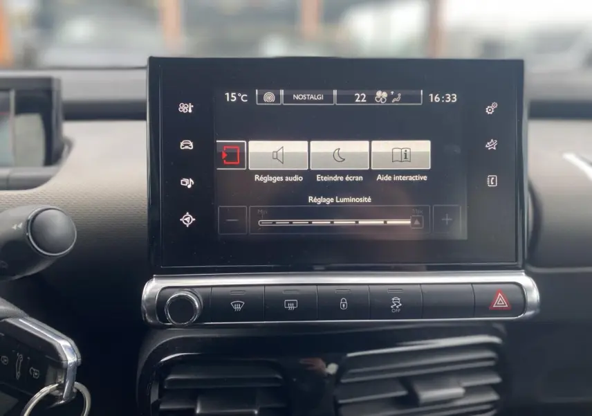 Écran tactile central du tableau de bord d'une Citroën C4 Cactus 2015, affichant les réglages audio et luminosité.