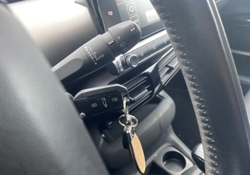 Gros plan sur le volant et la clé insérée du Citroën C4 Cactus blanc, avec tableau de bord et commandes visibles.