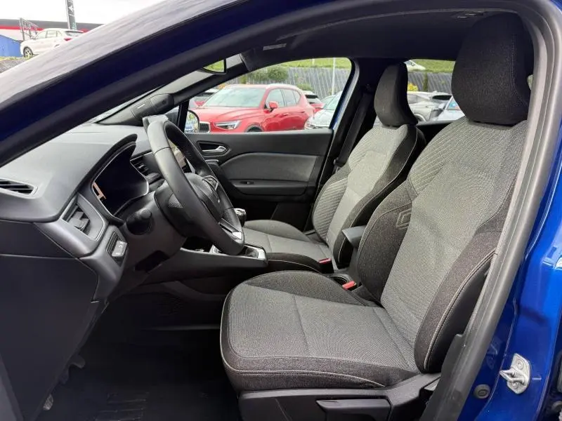 Vue intérieure côté gauche du Renault Captur 2025 Bleu Iron, montrant les sièges avant gris et le tableau de bord.