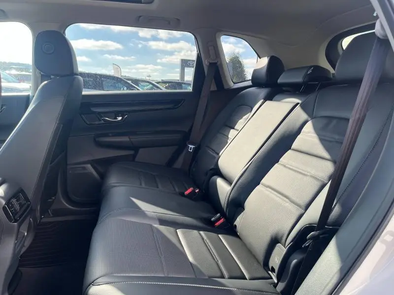 Vue intérieure côté droit des sièges arrière en cuir noir du Honda CR-V 2024 Executive hybride, avec ceintures et appuis-tête visibles.