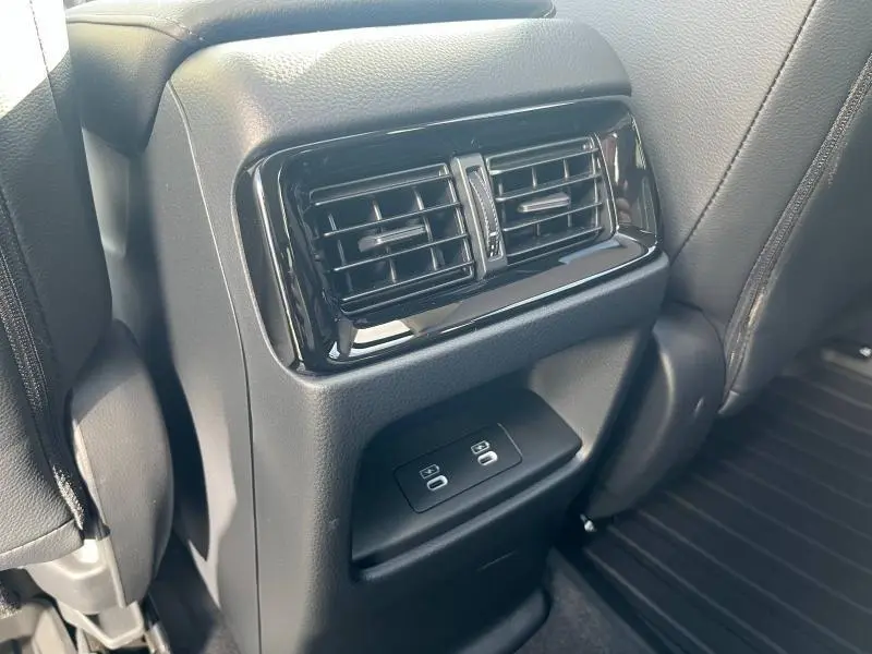 Buses d'aération arrière et ports USB noirs du Honda CR-V 2024 vus de près entre les sièges arrière en cuir noir.