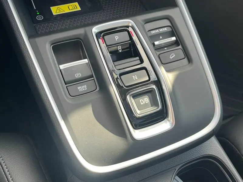 Gros plan sur la console centrale noire du Honda CR-V 2024 avec commandes de boîte auto et mode de conduite.