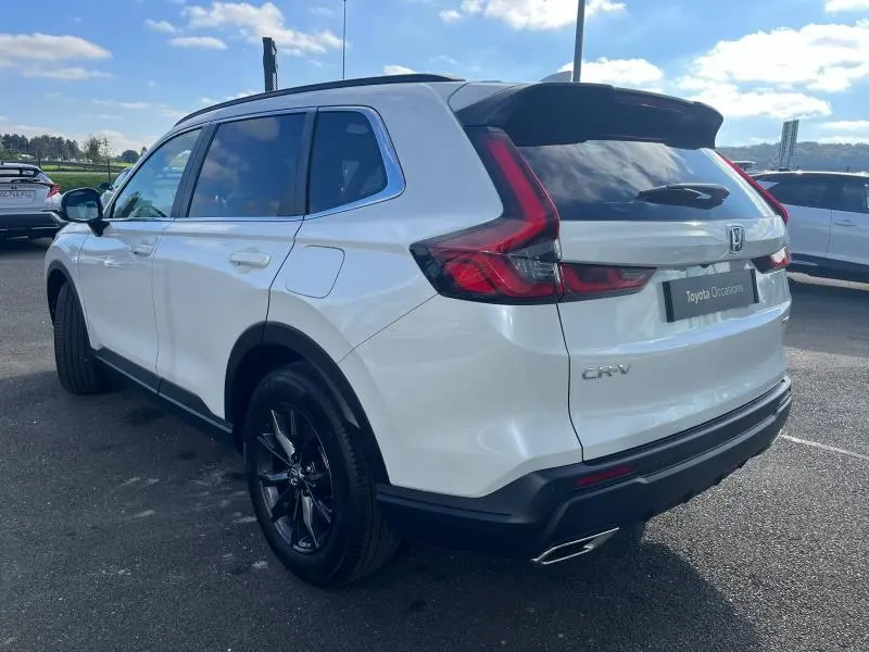 Vue 3/4 arrière droite du Honda CR-V 2024 blanc Diamant Brillant Premium avec feux arrière LED et jantes noires.