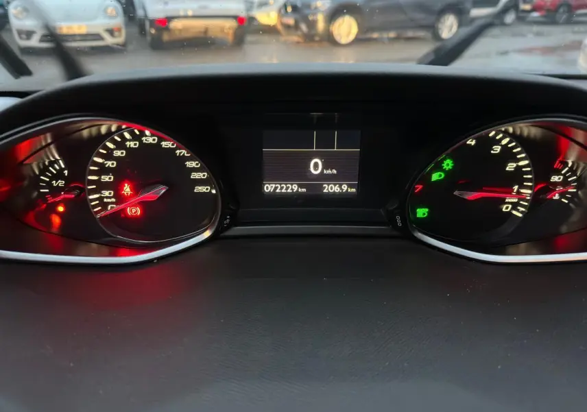 Vue rapprochée du tableau de bord de la Peugeot 308 2018, affichant le compteur, la vitesse à zéro et les voyants allumés.