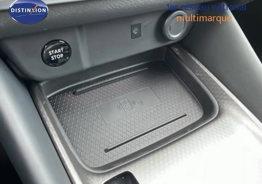 Gros plan sur la console centrale du Nissan Qashqai 2025, montrant le plateau de recharge sans fil et le bouton Start/Stop.