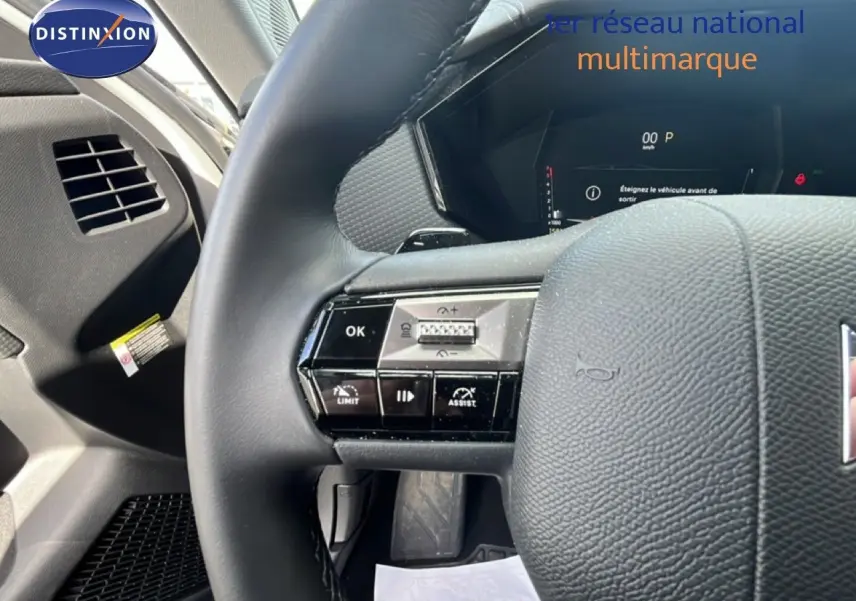 Gros plan sur le volant noir et les commandes multifonctions du DS4 1.5 BlueHDi 130ch, tableau de bord digital en arrière-plan.