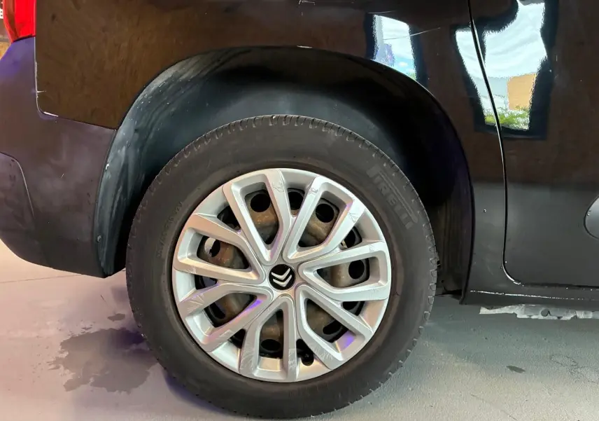 Gros plan sur la roue arrière droite noire d’un Citroën Berlingo 1.5 BlueHDi 100 avec jante argentée distinctive.
