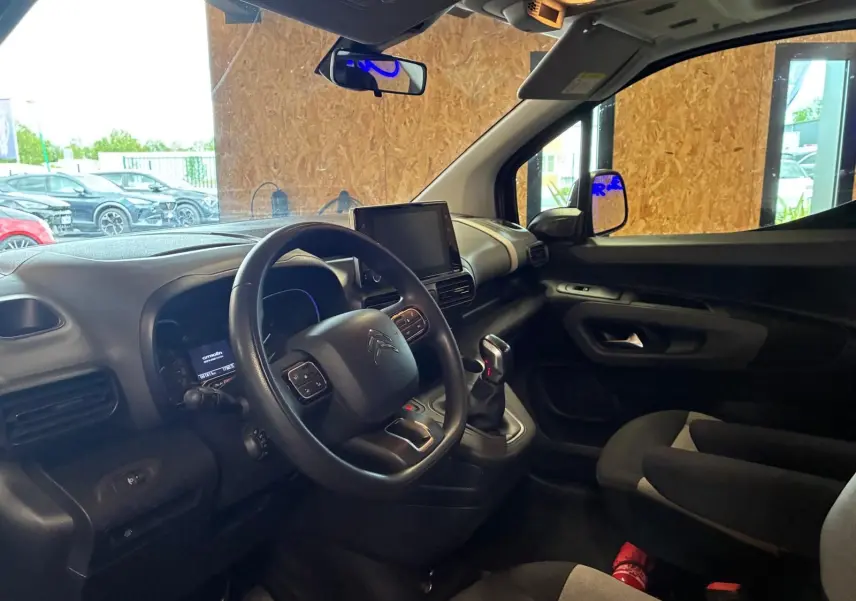 Vue intérieure côté conducteur du Citroën Berlingo noir 2020, montrant le tableau de bord et la console centrale avec écran tactile.