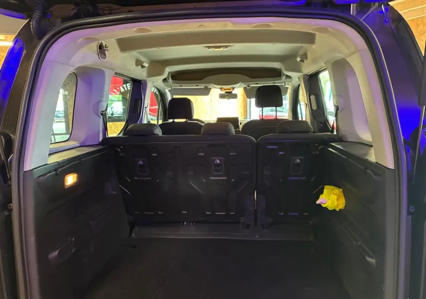 Vue intérieure arrière du Citroën Berlingo noir 2020, montrant le coffre spacieux et les sièges arrière en tissu noir.