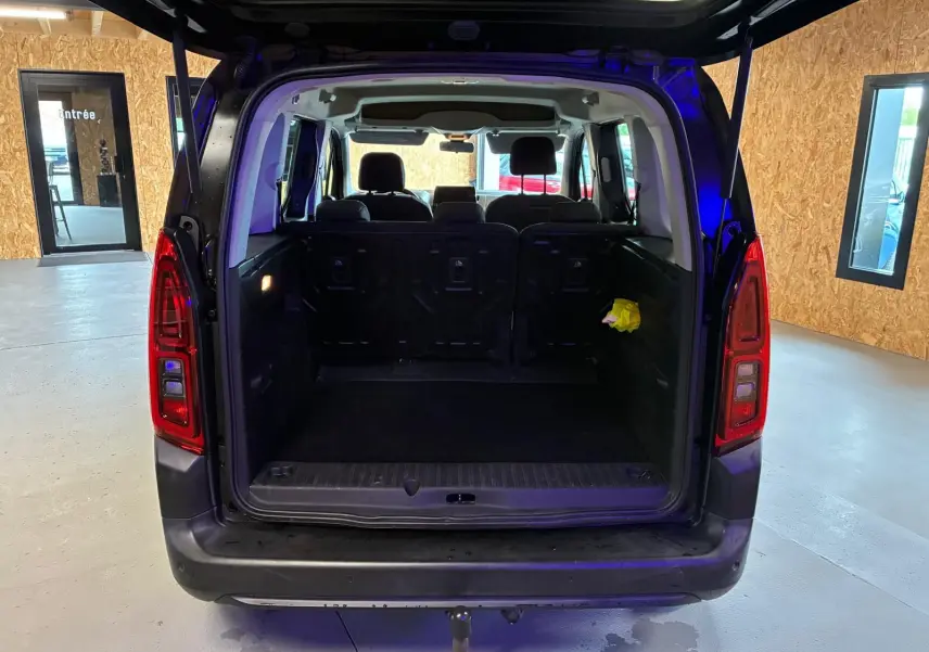 Vue arrière ouverte du Citroën Berlingo noir 2020 montrant le grand coffre vide et les sièges arrière en tissu noir.