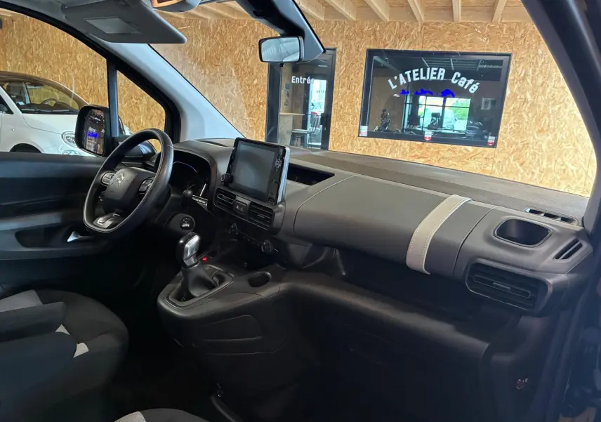 Vue intérieure côté conducteur du Citroën Berlingo noir 2020, avec tableau de bord moderne et écran tactile central.