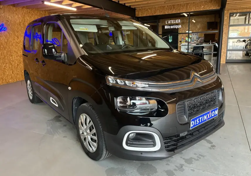 Vue 3/4 avant droit d'un Citroën Berlingo noir 2020, avec calandre distinctive et phares modernes, en intérieur d'atelier.