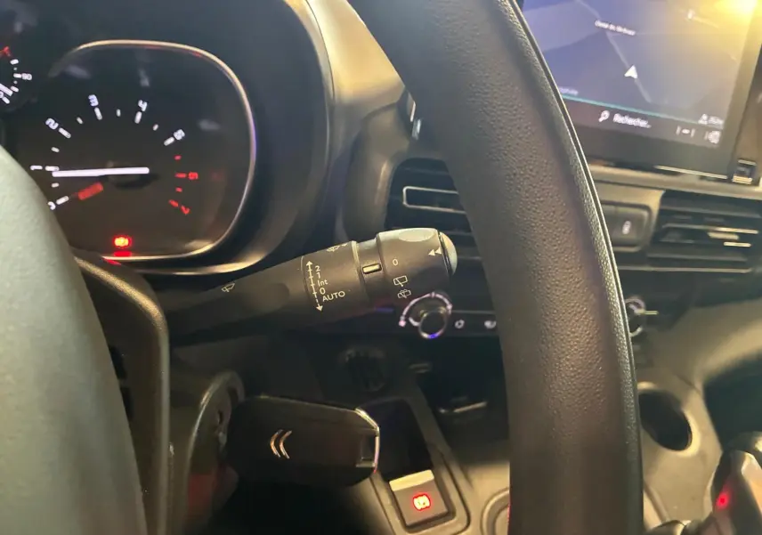 Vue rapprochée du volant côté gauche du Citroën Berlingo noir 2020, avec commandes au volant et écran GPS visible.