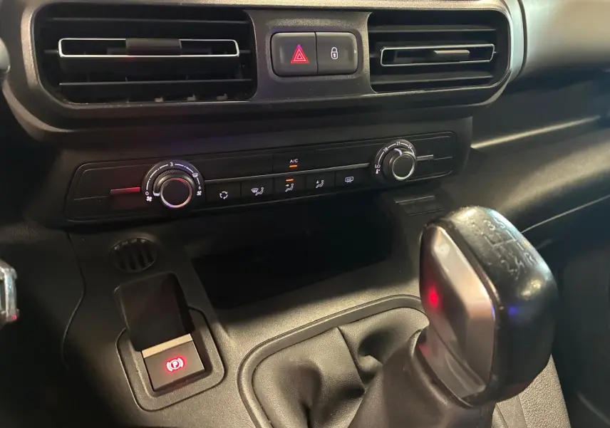 Vue rapprochée de la console centrale du Citroën Berlingo noir 2020, avec levier de vitesse manuel et commandes climatisation.