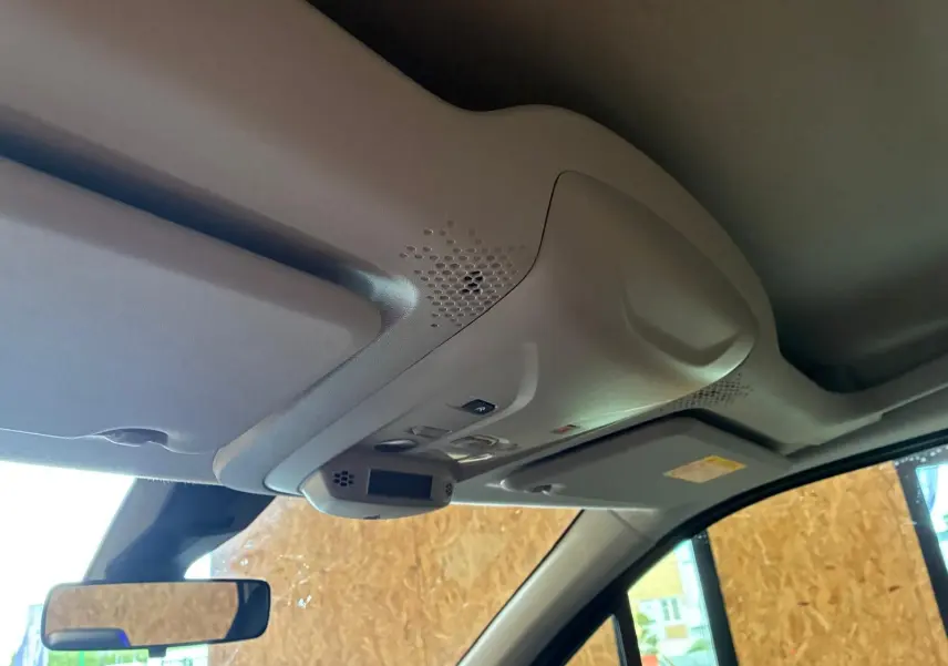 Vue intérieure du plafond avant du Citroën Berlingo noir 2020, montrant les commandes d'éclairage et le pare-soleil côté conducteur.