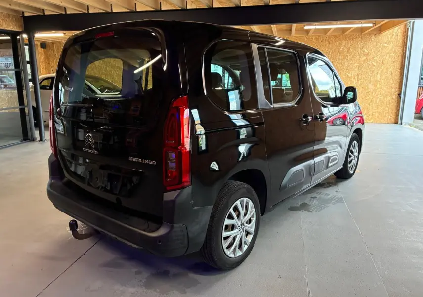 Vue 3/4 arrière droite d'un Citroën Berlingo noir 2020 avec hayon, porte latérale coulissante et attelage visible.