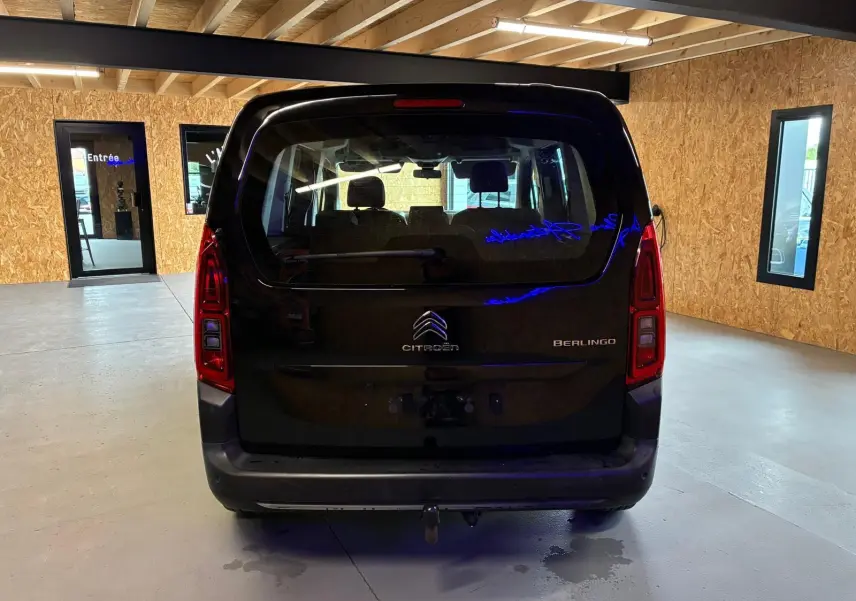 Vue arrière d'un Citroën Berlingo noir 2020 dans un garage avec attelage visible sous le pare-chocs.