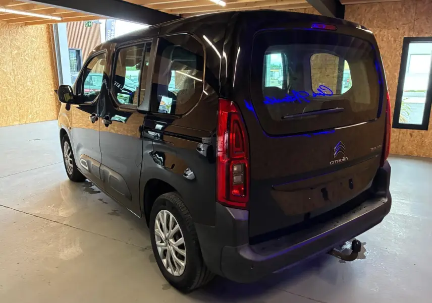 Vue 3/4 arrière droite d'un Citroën Berlingo noir 2020 avec hayon, feux arrière verticaux et attelage visible.