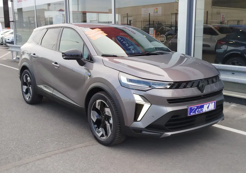 Renault Symbioz gris cassiopée métal en 3/4 avant droit, avec feux LED et jantes noires distinctives.