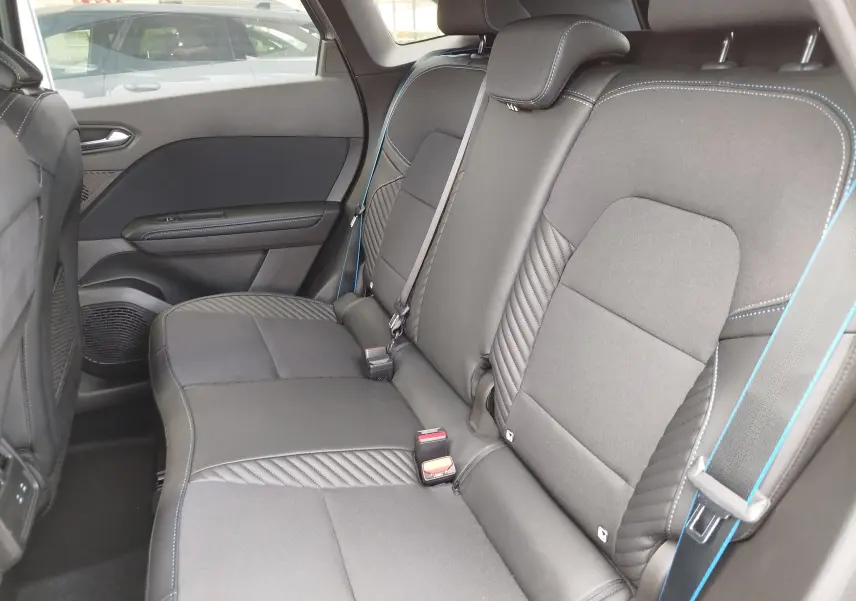 Vue latérale intérieure de la banquette arrière en tissu noir avec surpiqûres bleues du Renault Symbioz 2026.