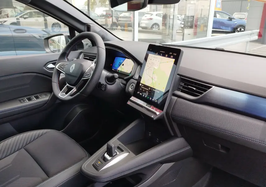 Vue intérieure côté gauche du Renault Symbioz gris cassiopée, avec tableau de bord numérique et écran tactile vertical central.