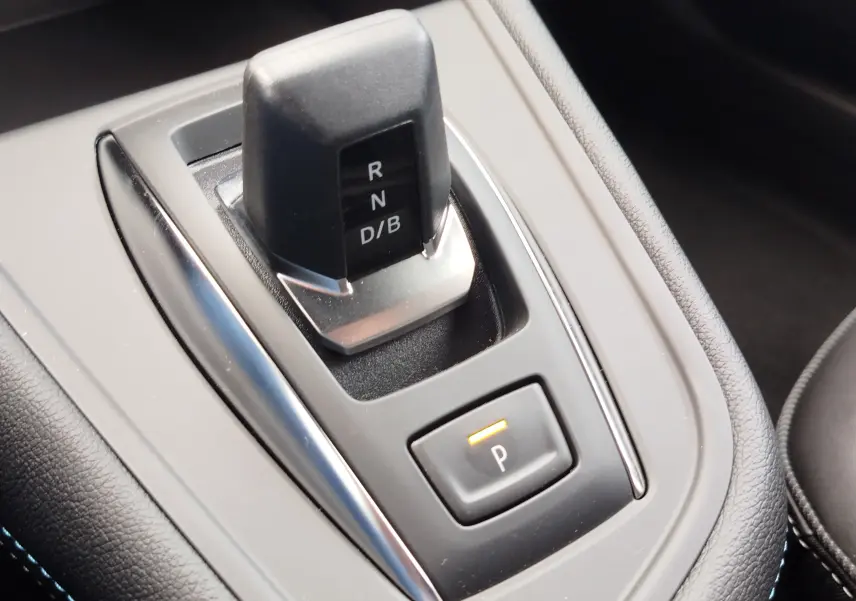 Gros plan sur la commande de boîte automatique noire et grise du Renault Symbioz, avec bouton de parking éclairé.