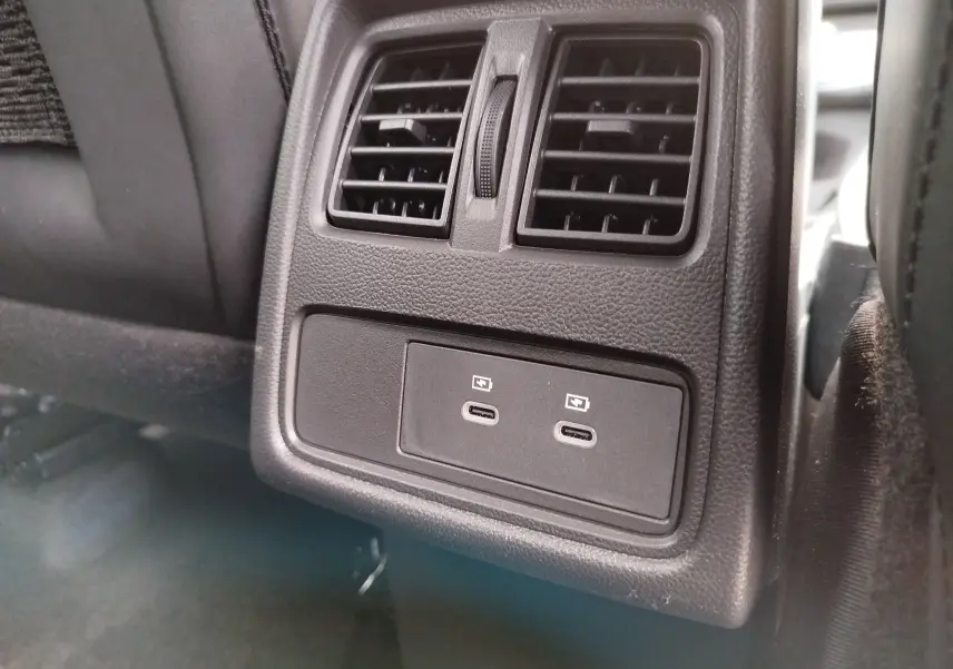 Vue rapprochée des prises USB-C doubles et des bouches d’aération arrière en plastique noir du Renault Symbioz 2026.