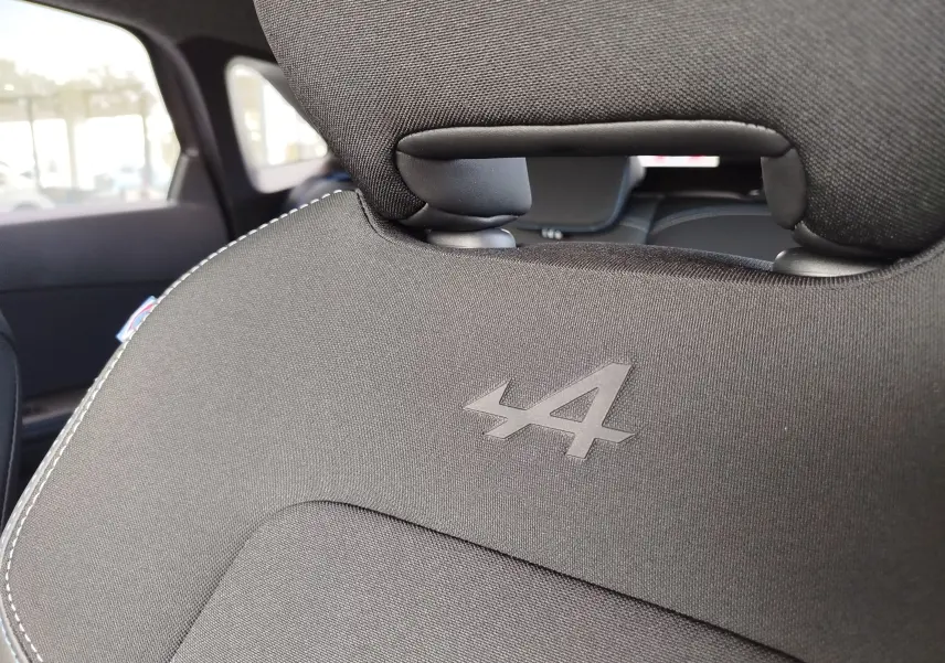 Gros plan sur le dossier de siège avant noir avec logo Alpine embossé, intérieur du Renault Symbioz 2026.