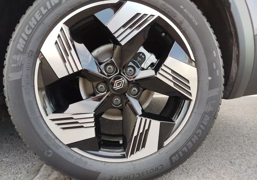 Gros plan sur la jante noire et argentée au design géométrique du Renault Symbioz gris Cassiopée Métal, pneu Michelin visible.