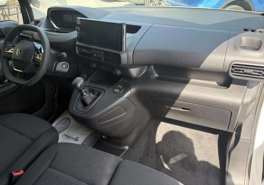 Vue intérieure côté conducteur du Peugeot Partner 2026 blanc, avec tableau de bord moderne et écran tactile central.