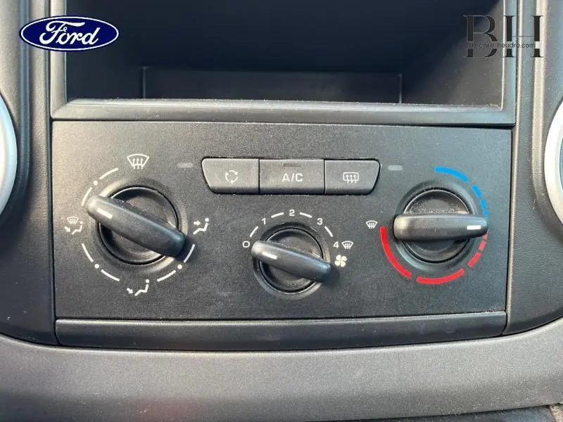 Panneau de commande de climatisation manuel noir dans un Ford, avec réglages de température, ventilation et air conditionné.