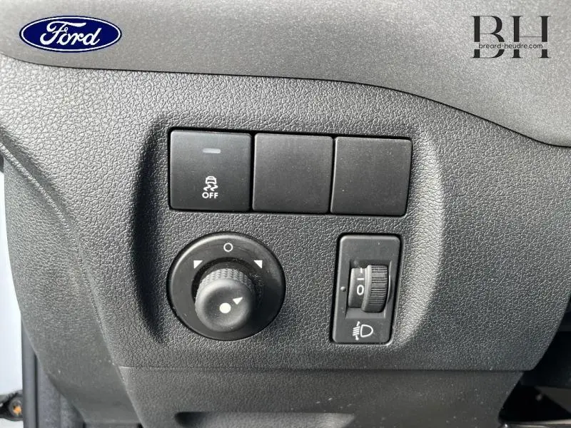 Gros plan sur les commandes de réglage des rétroviseurs et des phares d'un Citroën Berlingo blanc Banquise, version 2017.
