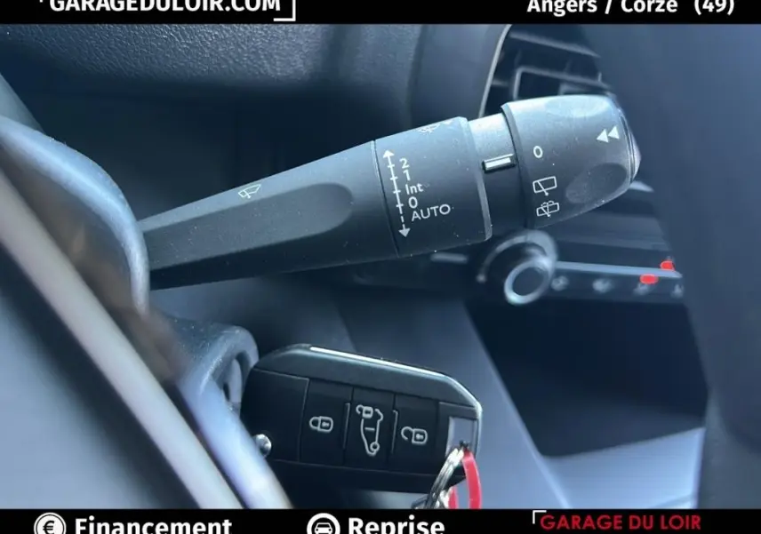 Détail du commodo d’essuie-glace et clé de contact dans l’habitacle du Peugeot Rifter bleu 2024.