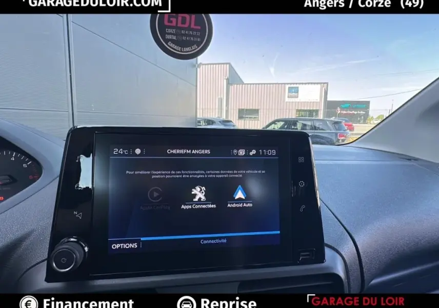 Vue intérieure du tableau de bord du Peugeot Rifter bleu 2024, écran tactile central affichant les apps connectées.