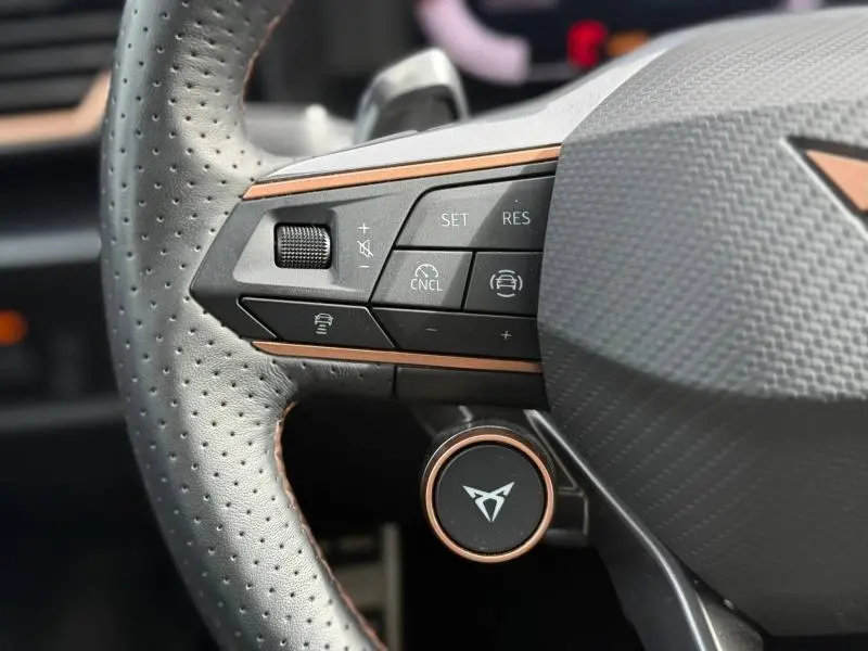 Gros plan sur le volant perforé du CUPRA Formentor 2025, avec commandes multifonctions et détails cuivrés.