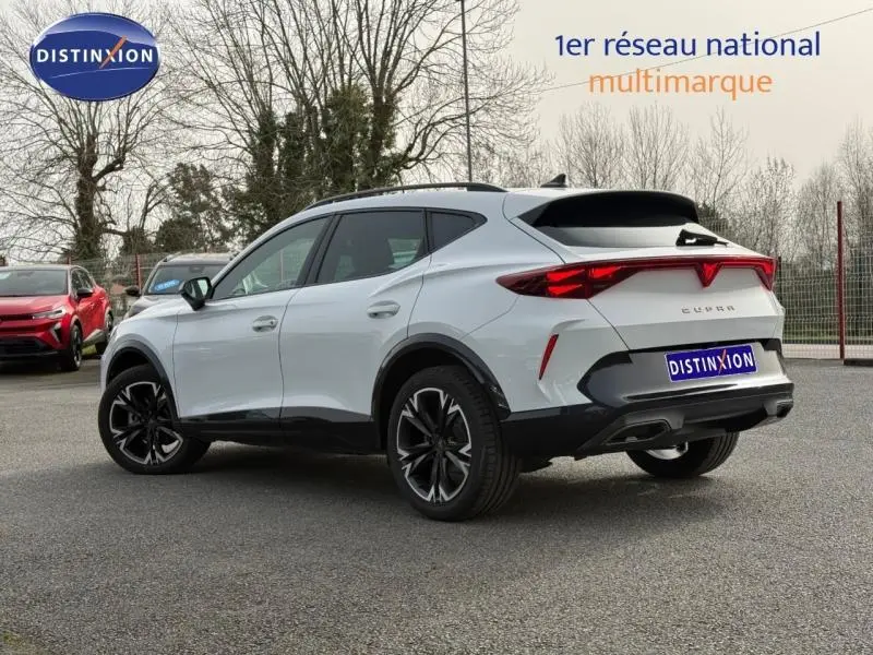 Vue 3/4 arrière droite d'un CUPRA Formentor blanc Nevada métallisé avec feux arrière distinctifs et jantes noires.