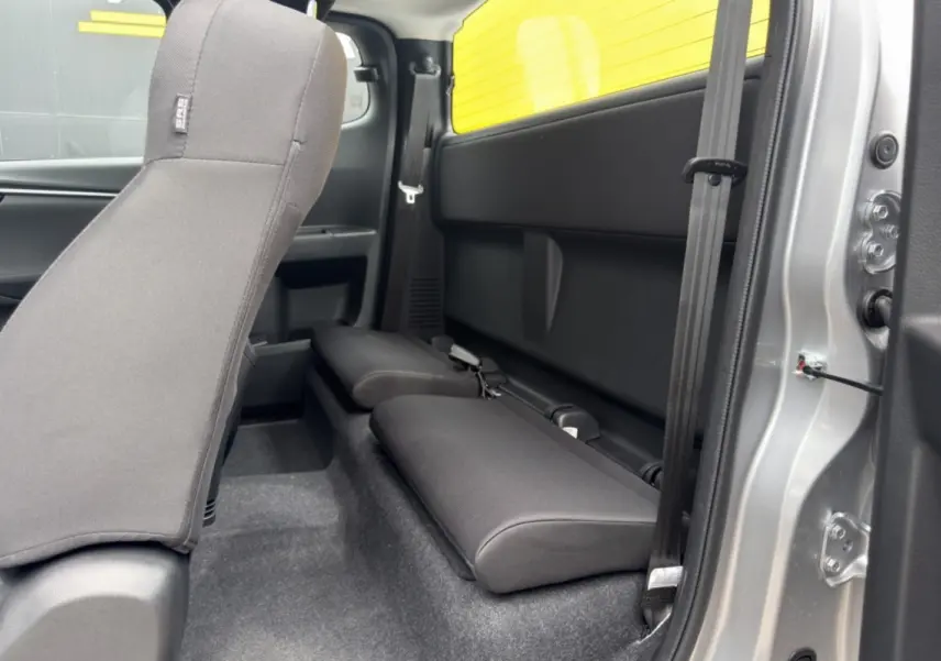 Vue intérieure côté droit du pick-up Isuzu D-MAX 2026 Mercury silver, montrant les strapontins arrière en tissu noir.