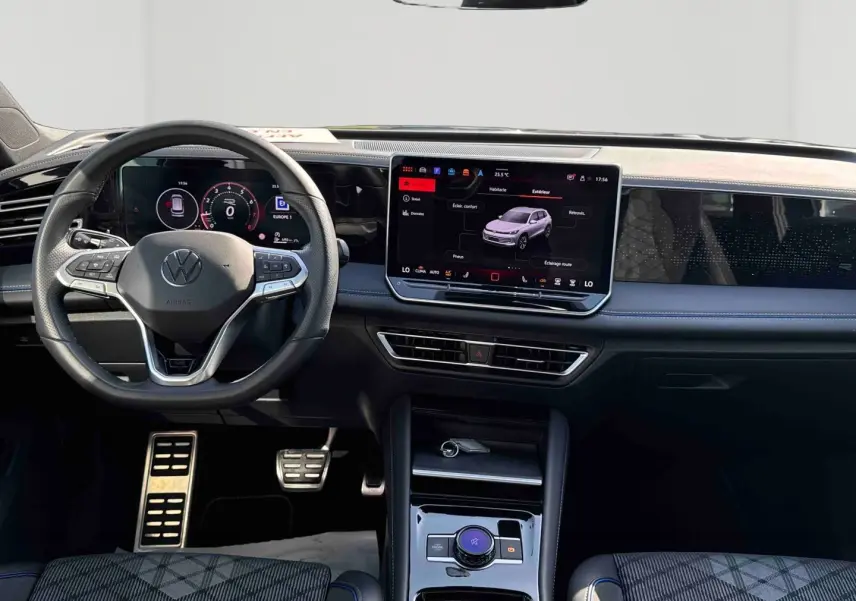 Vue intérieure frontale du Volkswagen Tiguan 2025 avec tableau de bord numérique et écran tactile central lumineux.