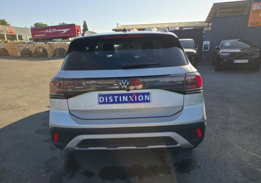 Vue arrière d'un Volkswagen T-Cross gris métallisé 2025 avec feux arrière LED et lunette teintée.