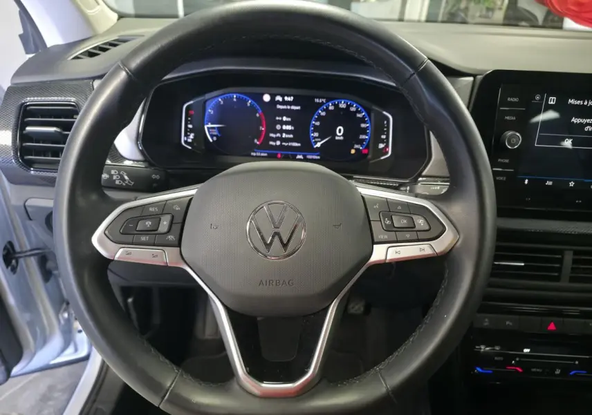 Vue rapprochée du volant en cuir noir et du combiné digital du Volkswagen T-Cross gris 2025, version Life.