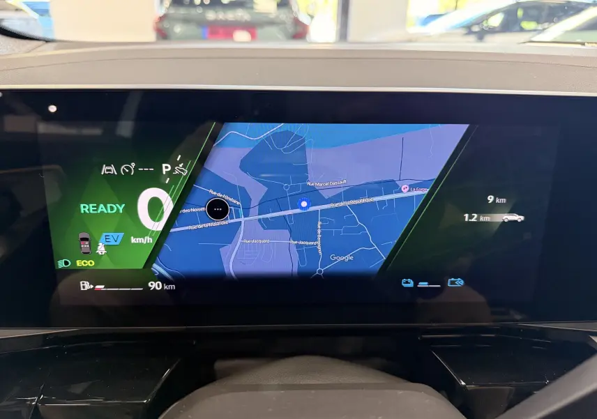 Affichage numérique intérieur du tableau de bord Renault Austral 2026, avec navigation GPS et indicateurs de conduite hybride.