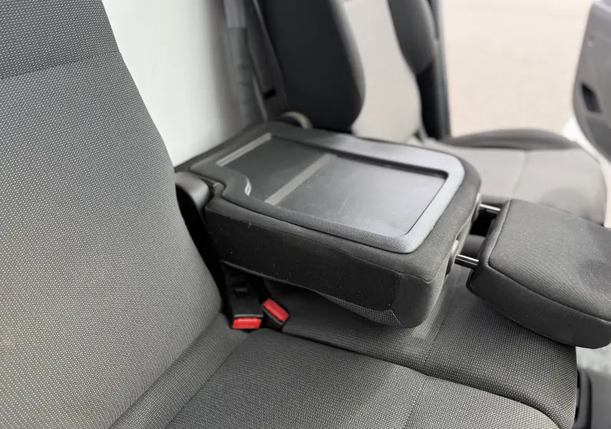 Gros plan sur les sièges avant gris foncé du Peugeot Partner 1.5 HDI 75 avec accoudoir central relevé.