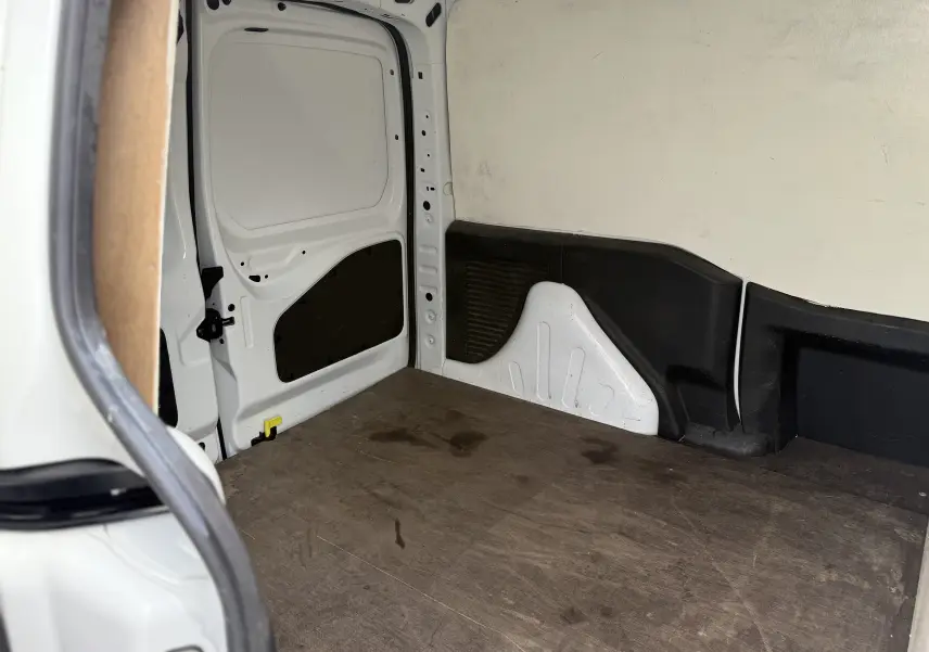 Vue intérieure arrière du Peugeot Partner blanc 2017 montrant l'espace de chargement avec plancher en bois et parois blanches.