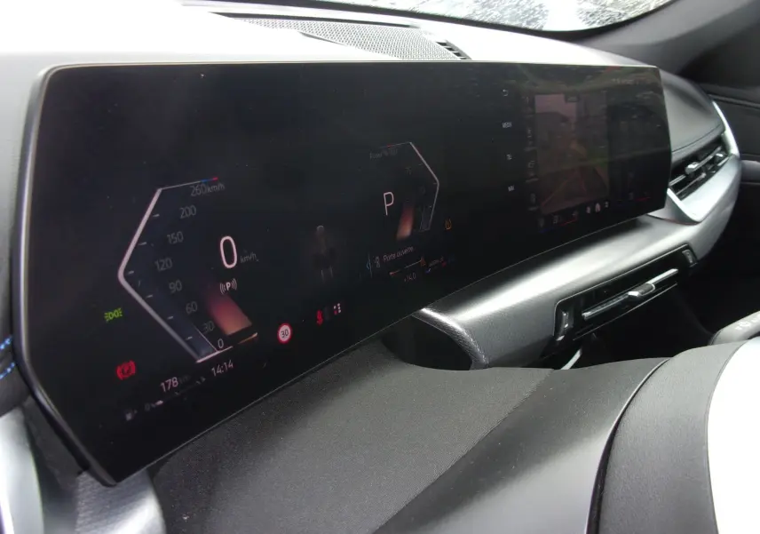 Vue rapprochée du tableau de bord numérique et écran central du BMW X1 argent métallisé, affichant la vitesse et caméra de recul.