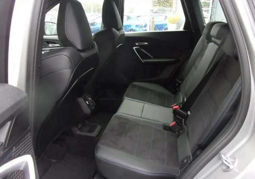 Vue intérieure arrière côté droit du BMW X1 argent métallisé 2024, sièges sport en cuir noir avec surpiqûres bleues.